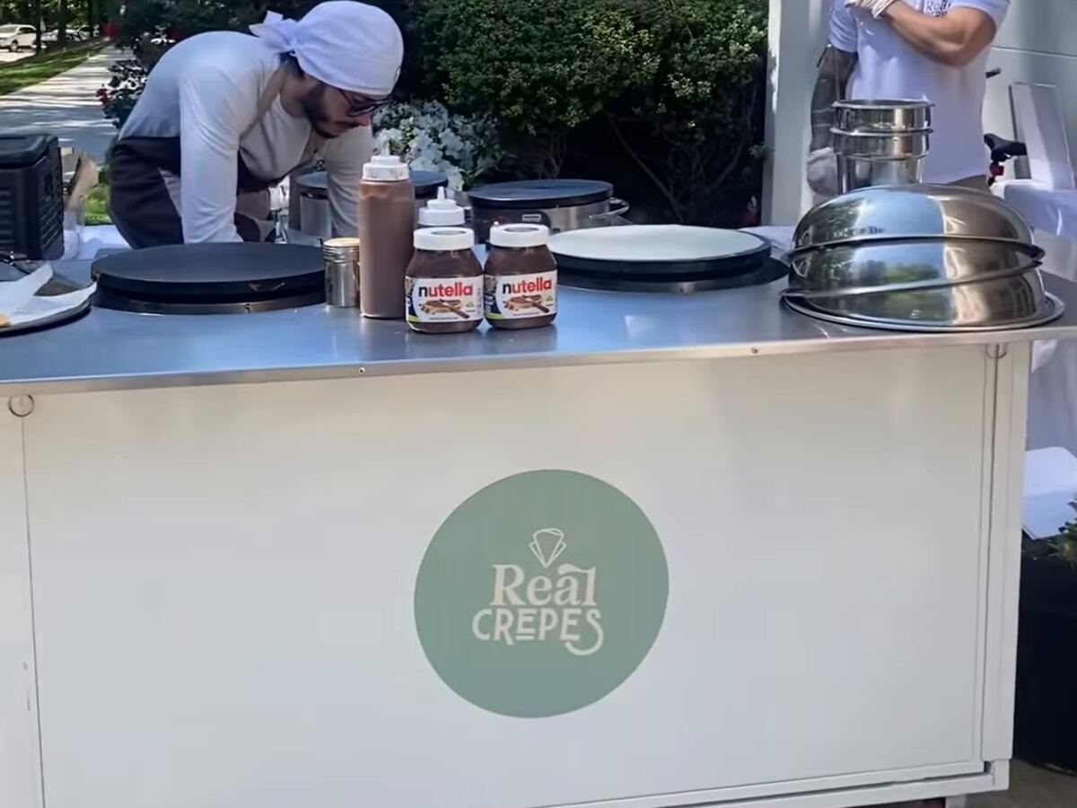The Real Crepes cart set up at a catered event, griddles hot and toppings ready.